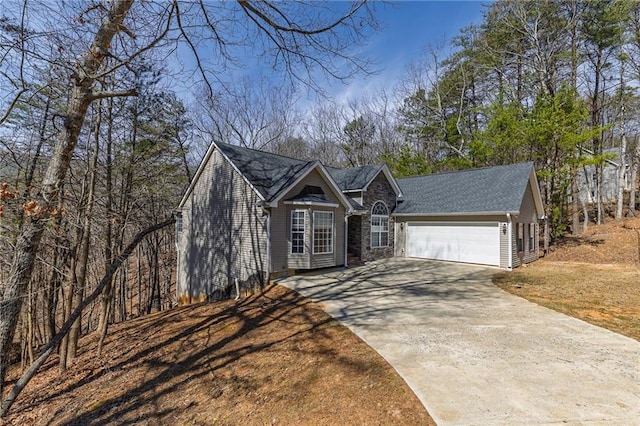 view of front of house with driveway, stone siding, and a garage