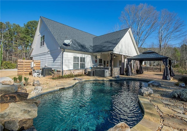 outdoor pool featuring central air condition unit, fence, and a gazebo