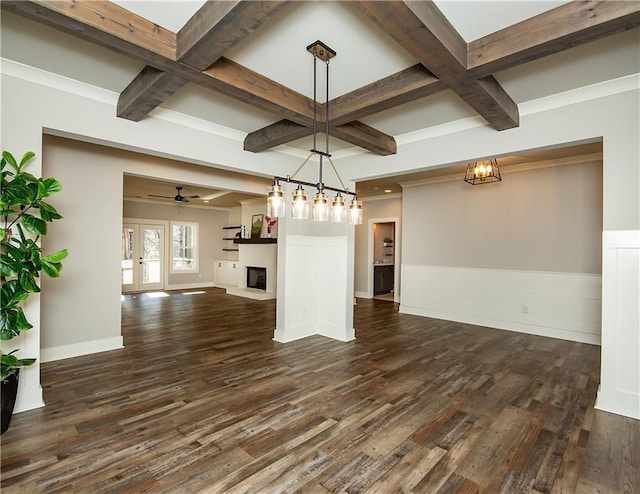 unfurnished dining area with a fireplace with raised hearth, coffered ceiling, and dark wood-style floors