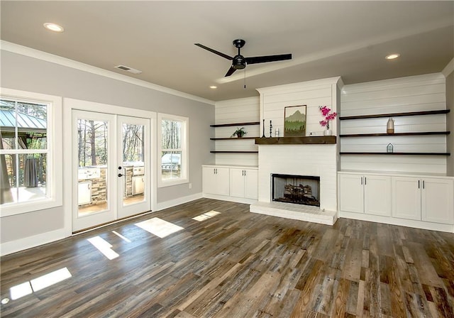 unfurnished living room with dark wood-style floors, visible vents, crown molding, and a fireplace