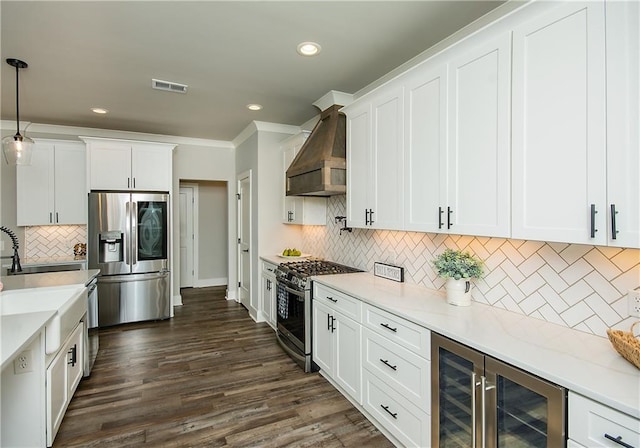 kitchen with wine cooler, visible vents, white cabinetry, wall chimney range hood, and appliances with stainless steel finishes