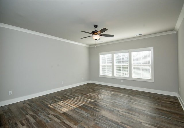 spare room featuring visible vents, ornamental molding, dark wood-type flooring, ceiling fan, and baseboards