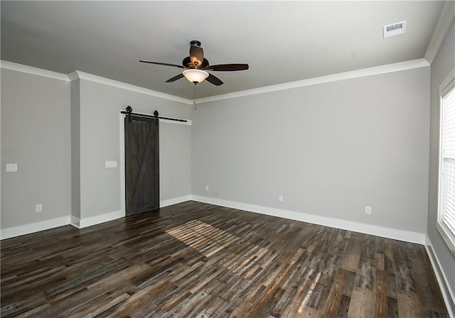 spare room featuring visible vents, a barn door, dark wood-type flooring, ornamental molding, and ceiling fan