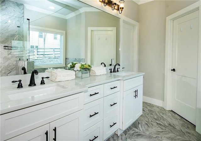 full bath with double vanity, a stall shower, baseboards, and a sink