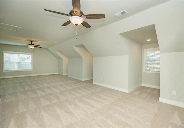 bonus room with baseboards, lofted ceiling, visible vents, and light colored carpet