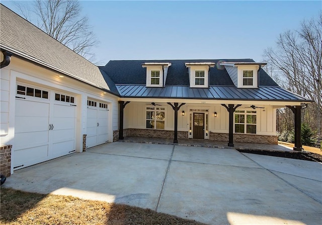 view of front facade featuring covered porch, concrete driveway, a standing seam roof, and board and batten siding