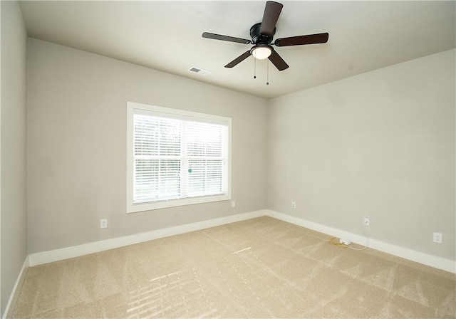 spare room featuring visible vents, light carpet, and baseboards