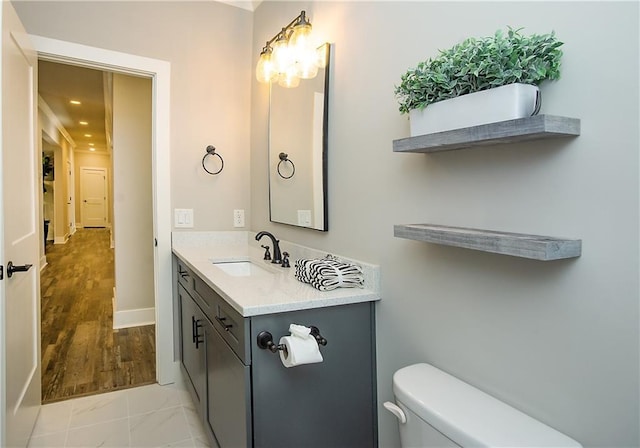 bathroom with recessed lighting, baseboards, vanity, and toilet