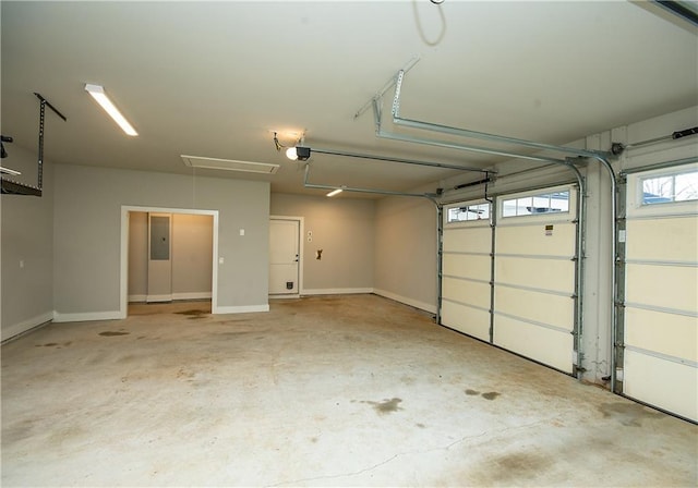 garage with baseboards, electric panel, and a garage door opener