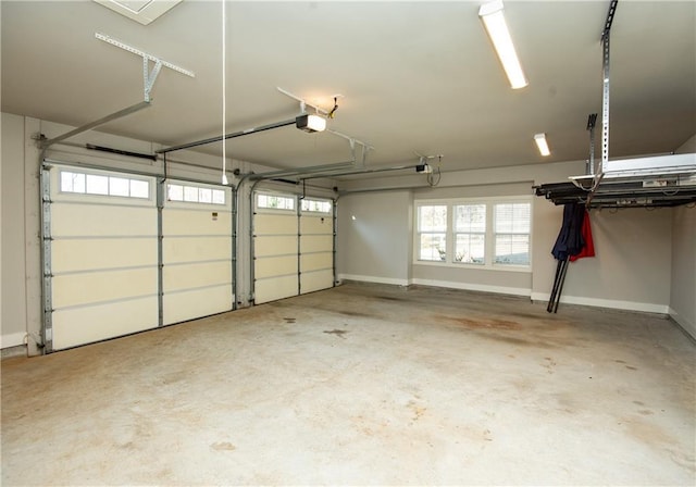 garage featuring a garage door opener and baseboards