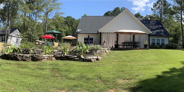 rear view of house featuring a lawn and board and batten siding