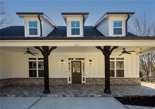 entrance to property featuring ceiling fan, brick siding, and board and batten siding