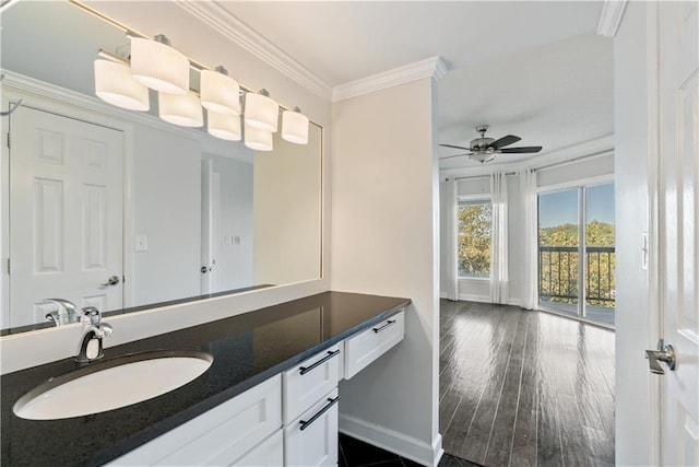 bathroom featuring vanity, wood finished floors, baseboards, ceiling fan, and crown molding