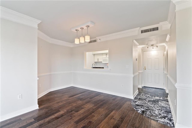 empty room featuring visible vents, baseboards, ornamental molding, and dark wood-style flooring