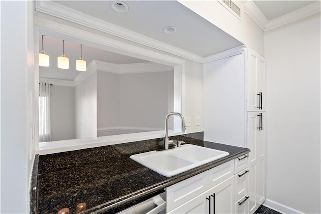 kitchen featuring visible vents, crown molding, dark stone counters, white cabinetry, and a sink