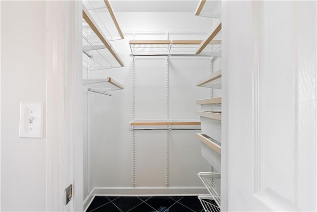 walk in closet featuring dark tile patterned flooring