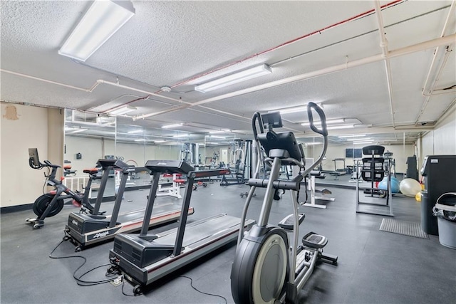 workout area with baseboards and a textured ceiling