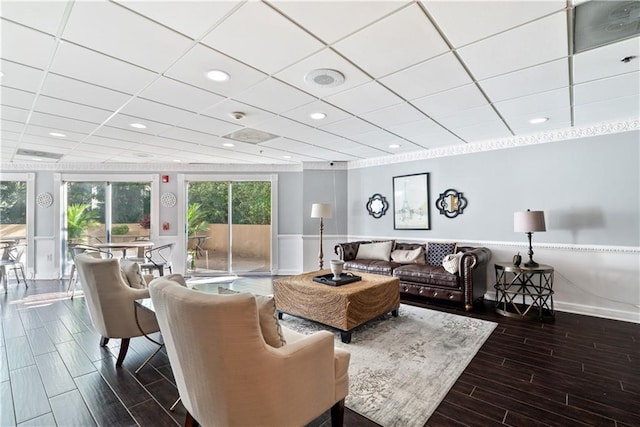 living room featuring a drop ceiling, recessed lighting, and wood tiled floor