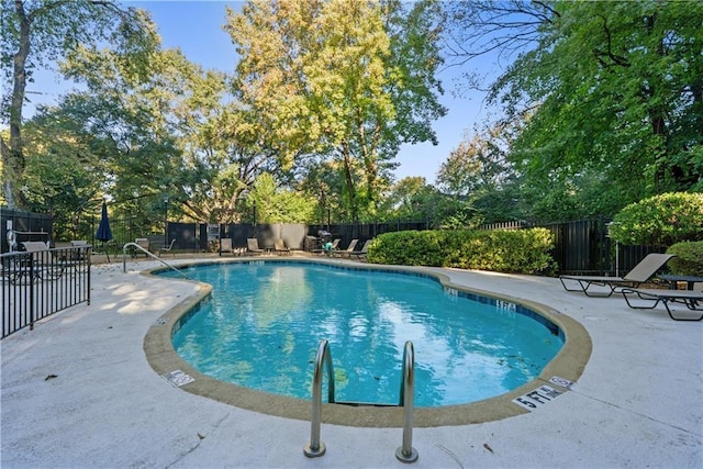 community pool featuring a patio and fence