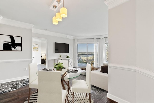 dining room featuring wood finished floors, baseboards, and ornamental molding