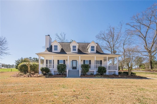 view of front of home with a porch, a front lawn, and a chimney