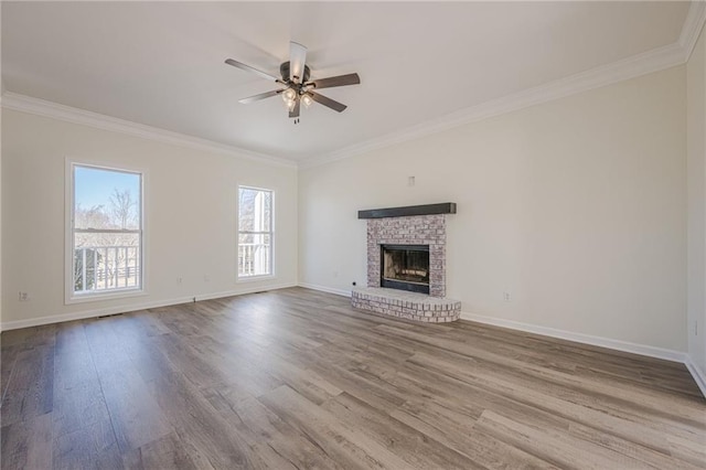 unfurnished living room featuring a fireplace, ornamental molding, and wood finished floors