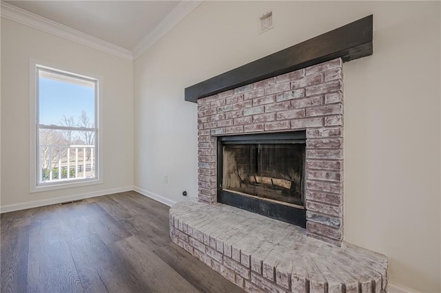 unfurnished living room with visible vents, baseboards, wood finished floors, crown molding, and a brick fireplace