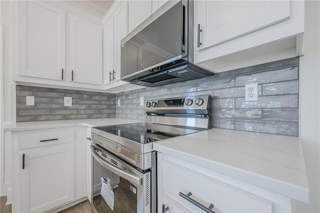 kitchen with white cabinets, light stone counters, wood finished floors, stainless steel appliances, and backsplash