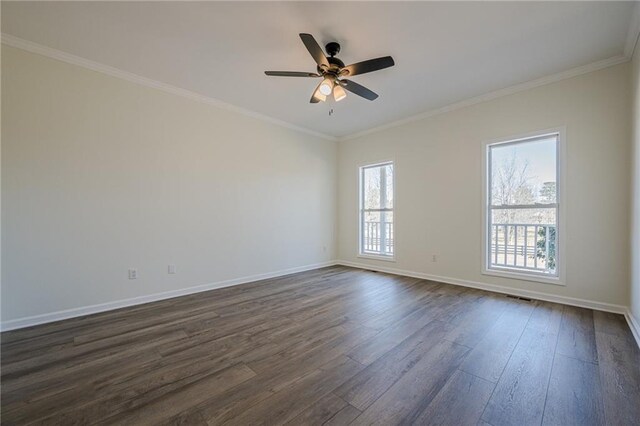 unfurnished room with ornamental molding, dark wood finished floors, a ceiling fan, and baseboards