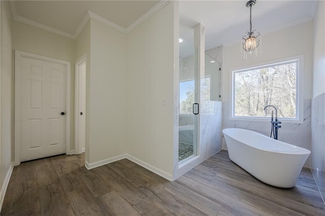 bathroom with a stall shower, a soaking tub, wood finished floors, and crown molding