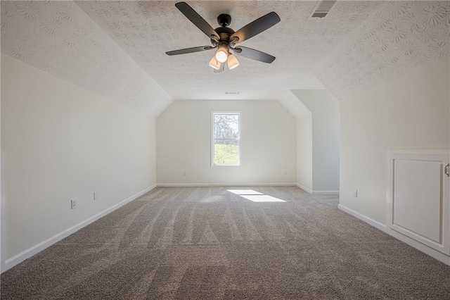 bonus room with light colored carpet, lofted ceiling, visible vents, and a textured ceiling