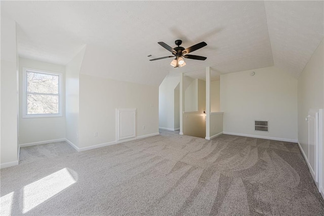 additional living space featuring baseboards, visible vents, lofted ceiling, ceiling fan, and carpet floors