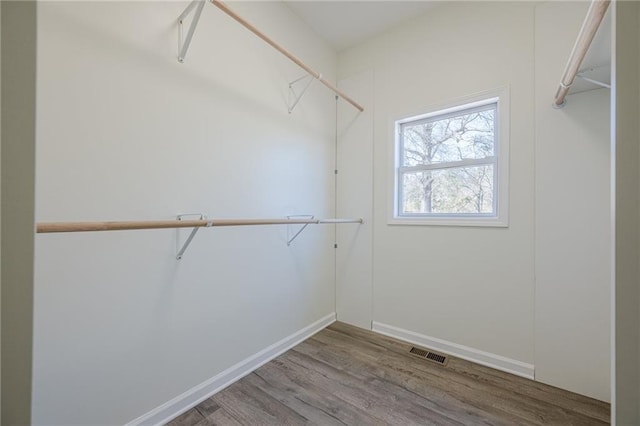 walk in closet with visible vents and wood finished floors