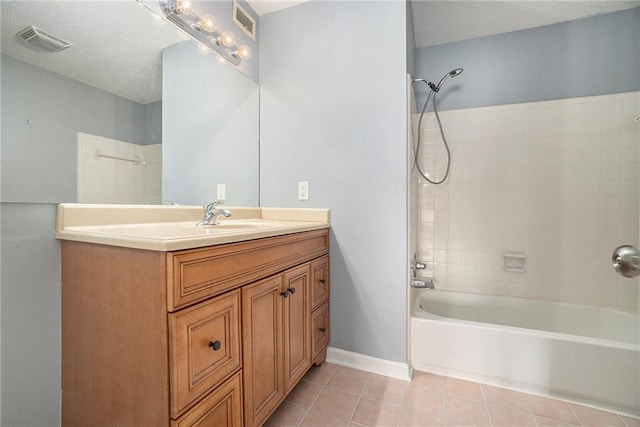 bathroom with tile patterned flooring, tiled shower / bath, vanity, and a textured ceiling