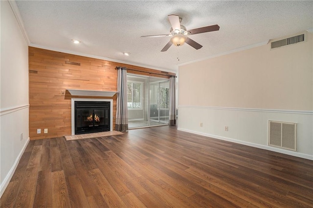 unfurnished living room with crown molding, dark wood-type flooring, ceiling fan, and a textured ceiling