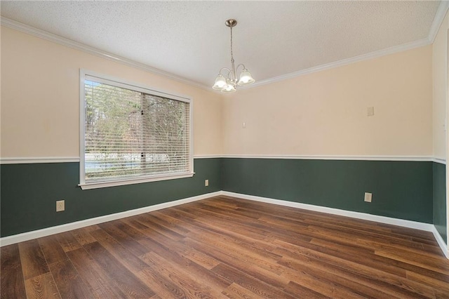 spare room featuring crown molding, dark wood-type flooring, a textured ceiling, and a chandelier