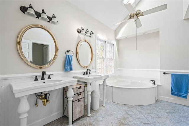 full bath featuring ceiling fan, a garden tub, and wainscoting