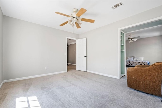 unfurnished bedroom with carpet, baseboards, visible vents, and ceiling fan