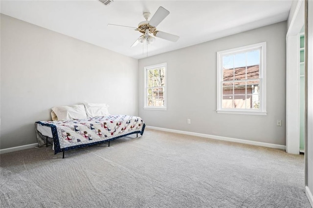 bedroom with baseboards, carpet floors, visible vents, and ceiling fan