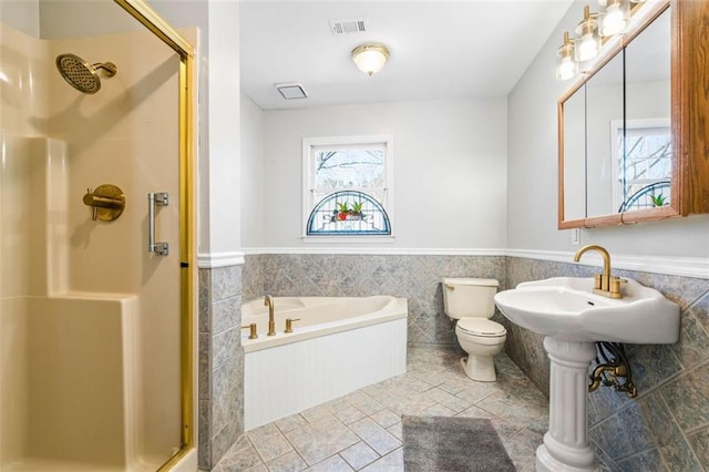 full bath featuring visible vents, a shower stall, toilet, wainscoting, and a bath