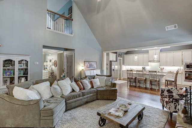 living room featuring a high ceiling and light hardwood / wood-style flooring