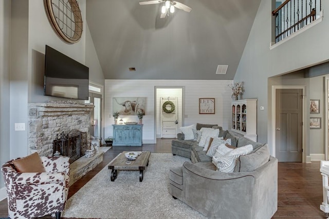 living room with ceiling fan, a fireplace, high vaulted ceiling, and dark wood-type flooring