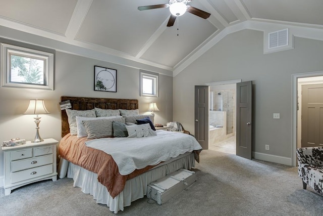 carpeted bedroom with ensuite bathroom, multiple windows, ceiling fan, and vaulted ceiling