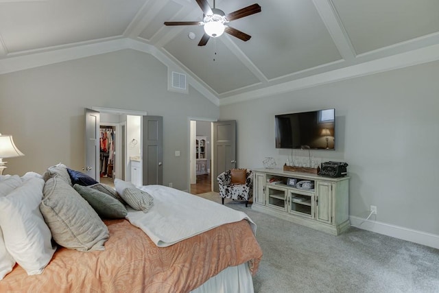 bedroom with light colored carpet, ceiling fan, a walk in closet, ensuite bath, and beam ceiling