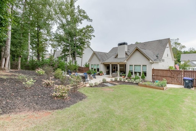 back of property with a patio and a yard