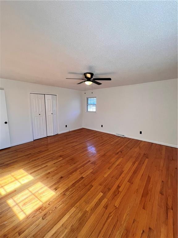 unfurnished bedroom featuring a textured ceiling, light wood-type flooring, and ceiling fan