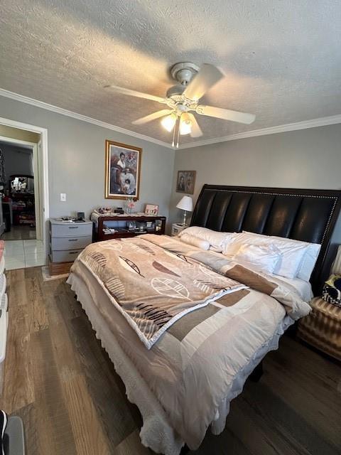 bedroom featuring a textured ceiling, ceiling fan, wood finished floors, and crown molding