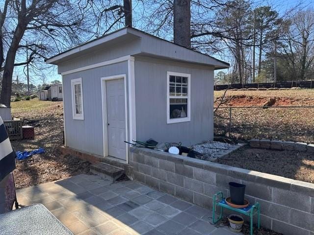 view of outdoor structure with entry steps, fence, and an outdoor structure