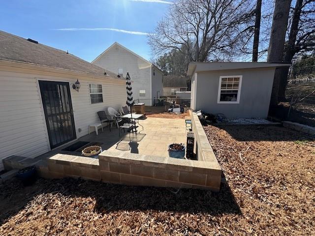 view of patio with an outdoor fire pit and an outdoor structure