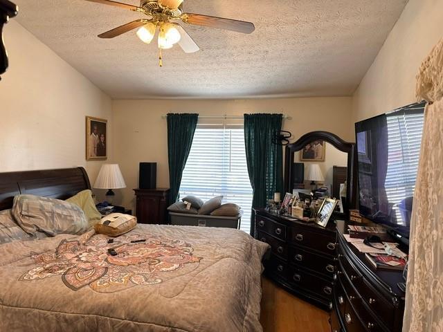 bedroom with multiple windows, vaulted ceiling, and wood finished floors